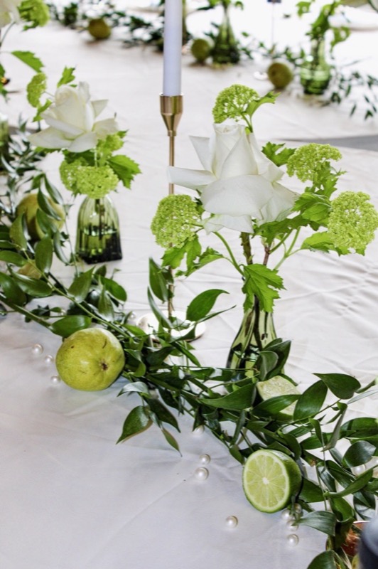 A refined green and citrus wedding tablescape with candles